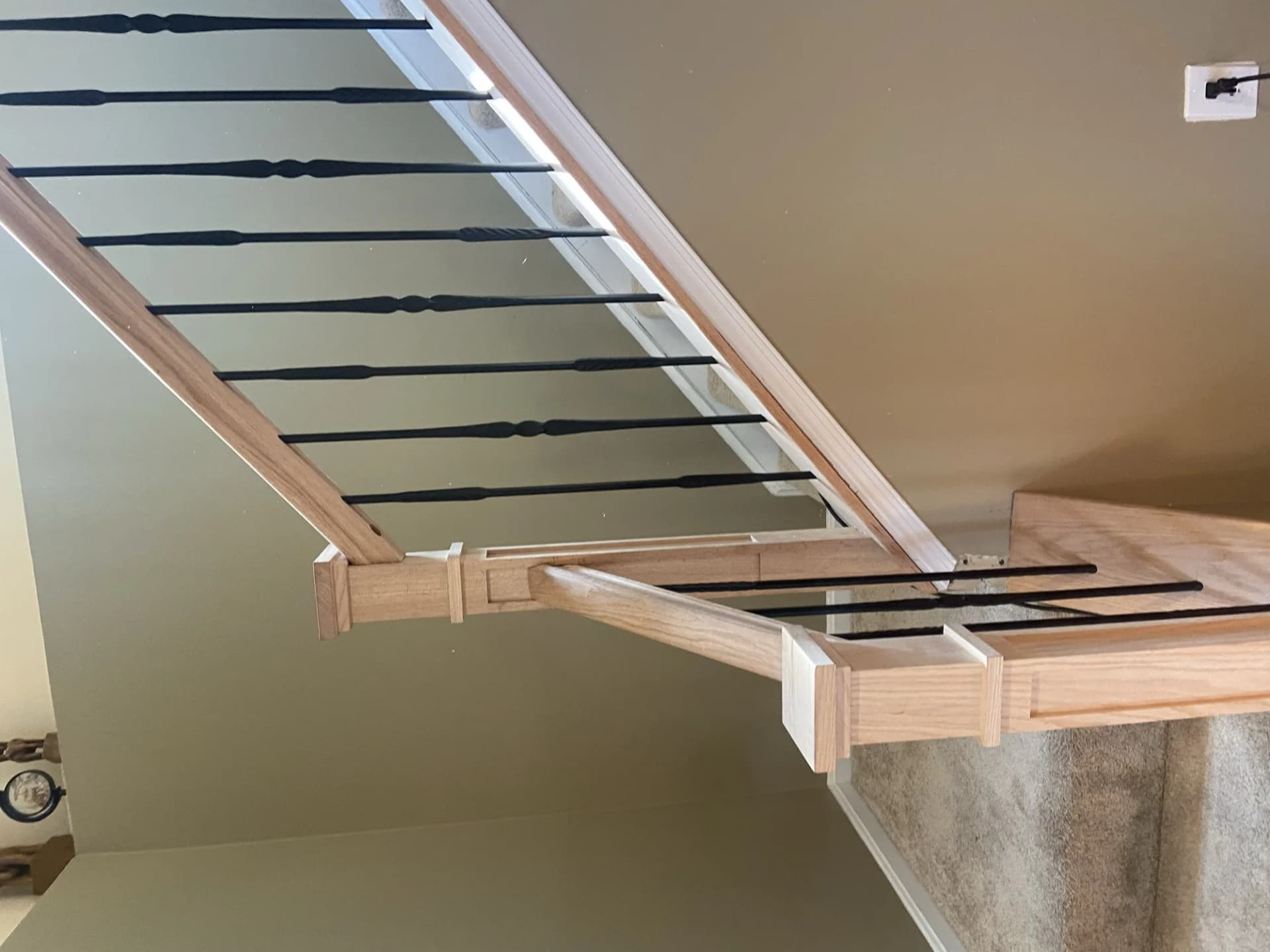 Oak stair railing with black iron balusters — installed by Local Expert Handyman in Alexandria VA