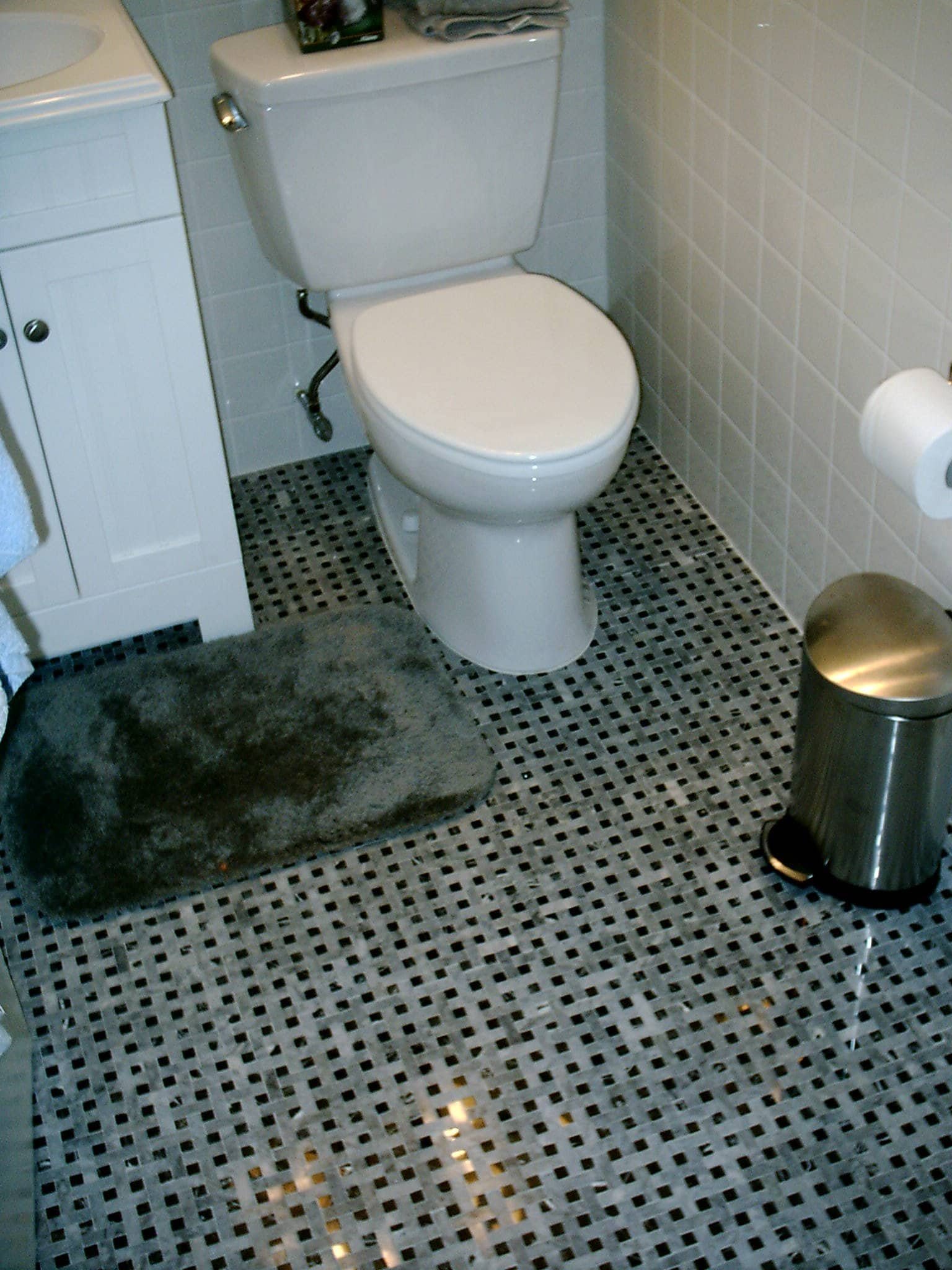 Toilet installation in a bathroom with new tile flooring, part of a bathroom remodeling project by l.