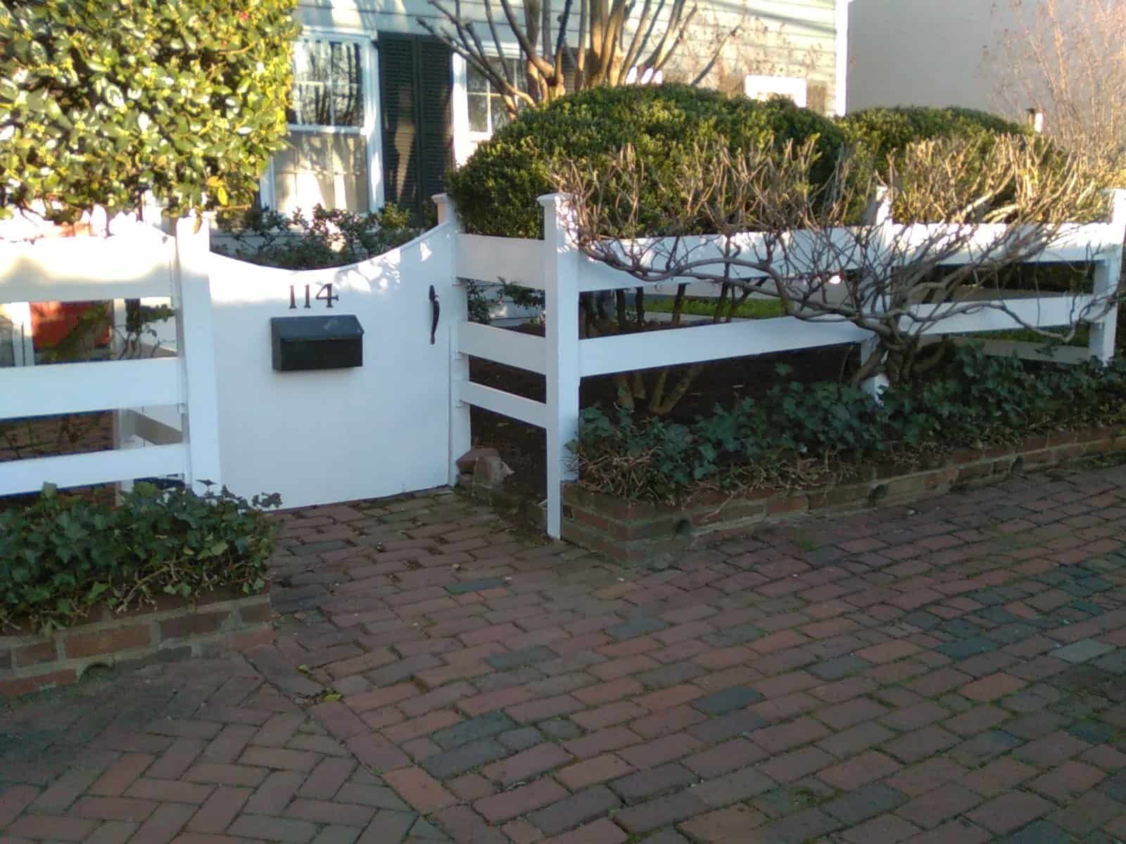 Outdoor fence repair and landscaping services for a charming house exterior.