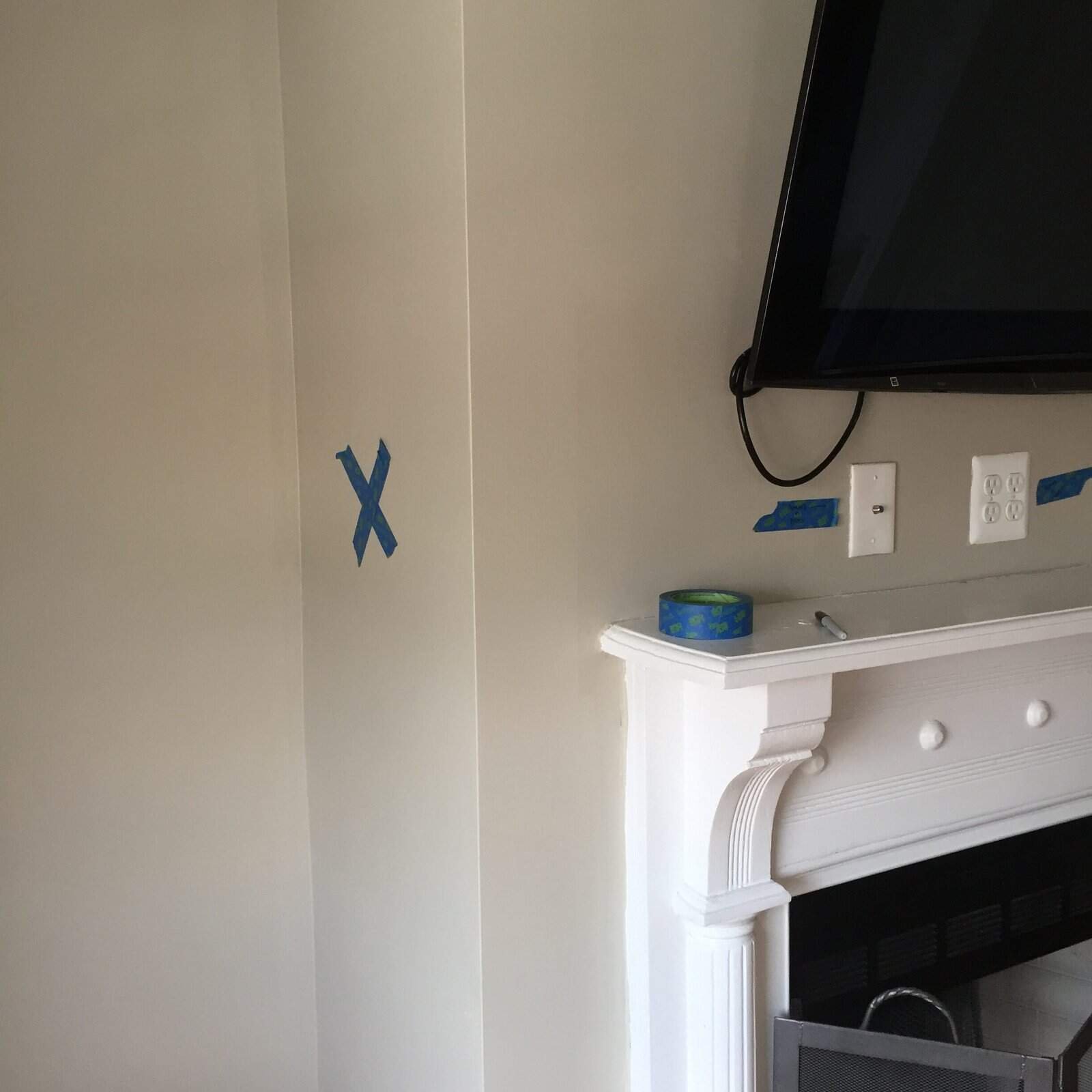 Interior door being installed in a home with tools and tape on the wall.